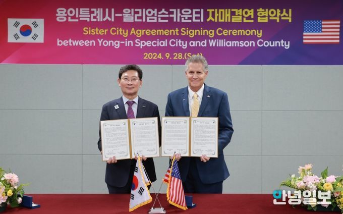 이상일 용인특례시장이 지난해 9월 용인시민의 날 행사 현장에서 빌 그래벨 미국 텍사스주 윌리엄슨 카운티장과 자매결연 협약을 맺고 협약서에 서명했다