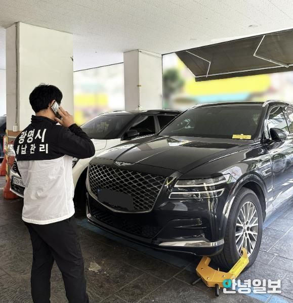 체납관리원이 체납차량에 대해 차량 이동제한장치를 설치하고 있는 모습.