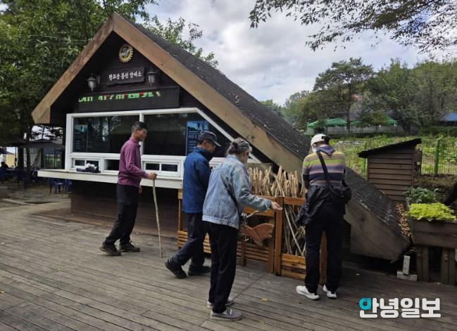 등산객들이 광교산 등산 안내소 앞에 있는 지팡이를 고르고 있다.