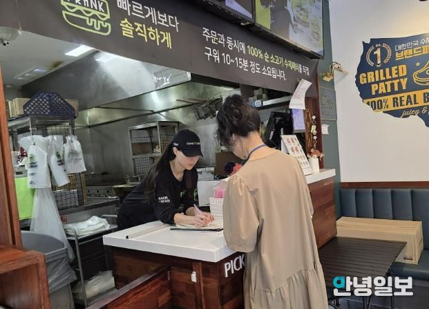 성남시 어린이 기호식품 전담관리원이 지난 9월 학교 주변 햄버거 판매점에서 영업자와 종업원의 건강진단 실시 여부를 점검하고 있다